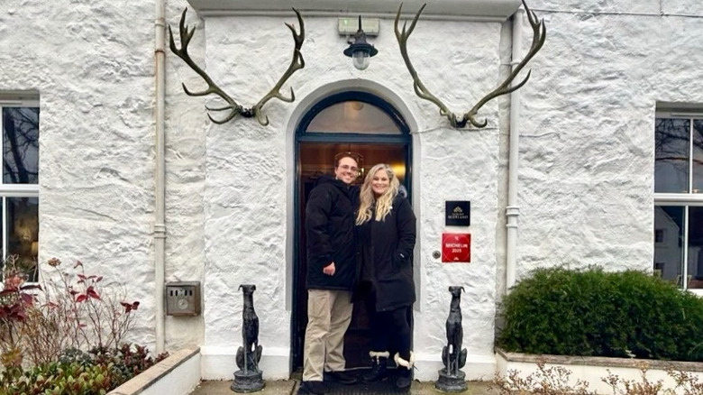 Ian Forrester and Whitney Thompson flanked by statues of dogs
