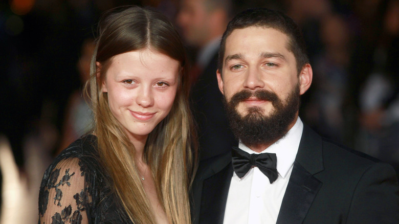 Mia Goth and Shia LeBeouf smiling for photos