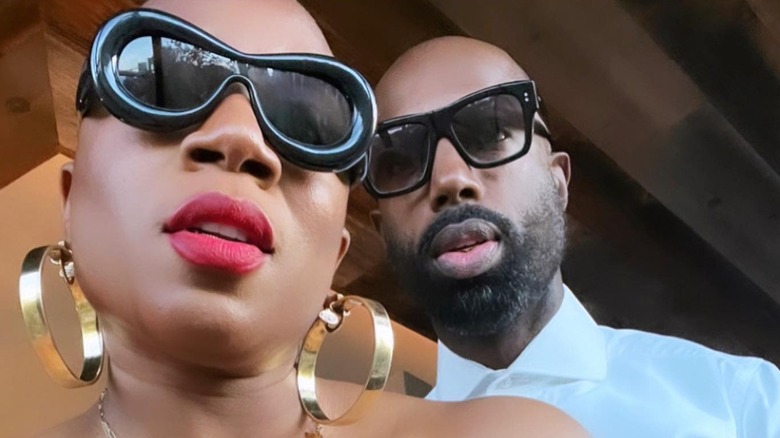 Aisha Hinds and Nigel Walker posing in black sunglasses