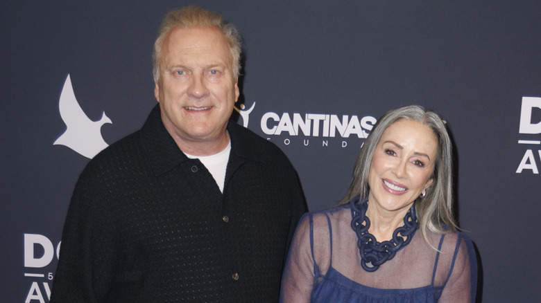 Patricia Heaton from "The Middle" smiling in a blue dress on the red carpet with her husband David Hunt