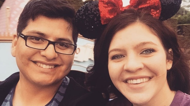 "The Middle" actor Blaine Saunders smiling in a selfie wearing Minnie Mouse ears next to her husband