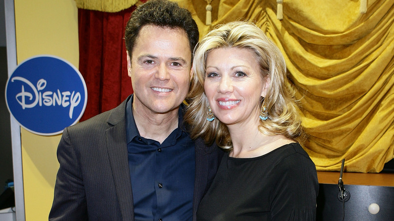 Donny and Debbie Osmond posing and smiling at a Disney event in 2010