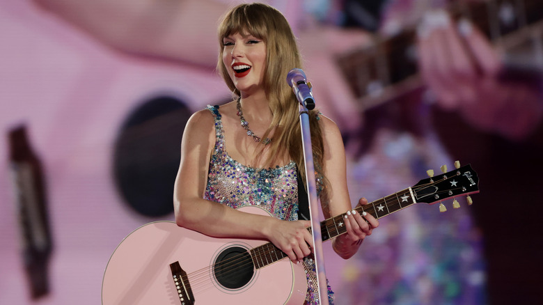Taylor Swift with pink guitar and silver sequin dress