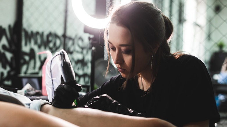 Woman doing tattoo