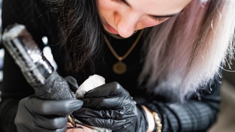 Woman doing tattoo