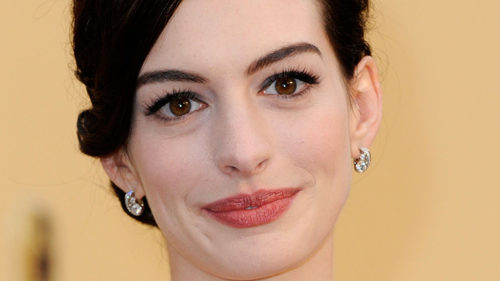 Anne Hathaway grinning with hair up