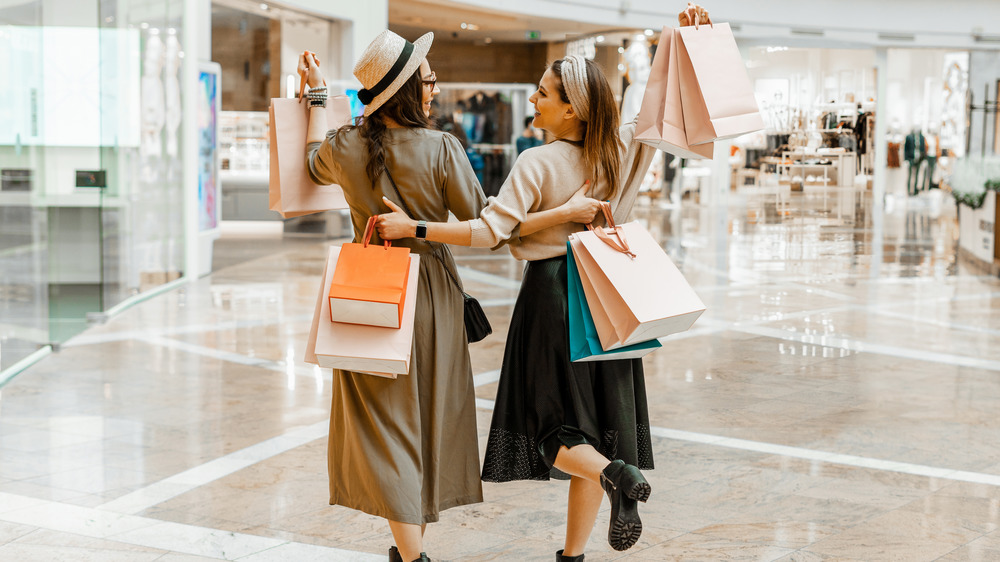 Two friends carrying shopping bags 