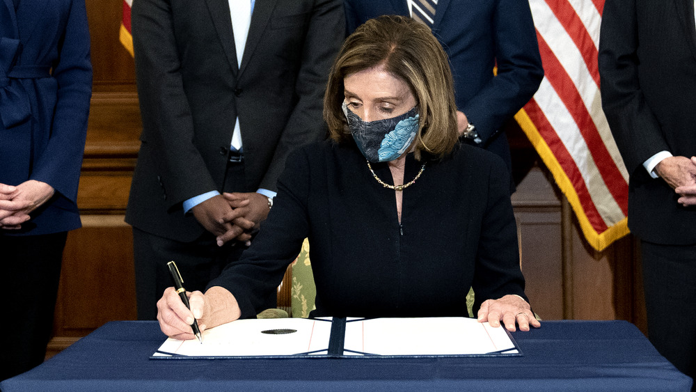 Nancy Pelosi signing articles of impeachment in mask