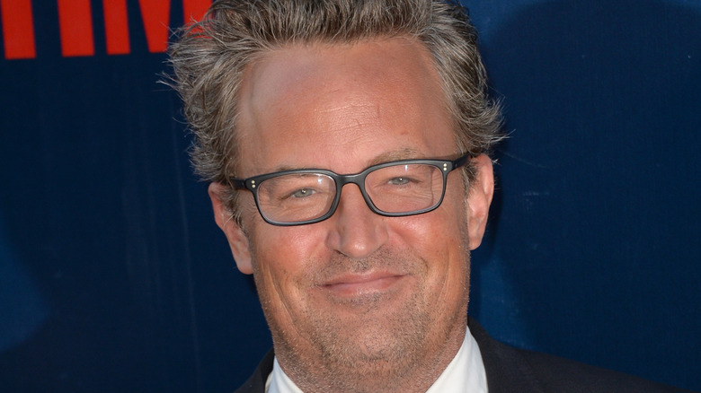 Matthew Perry smiles with glasses.