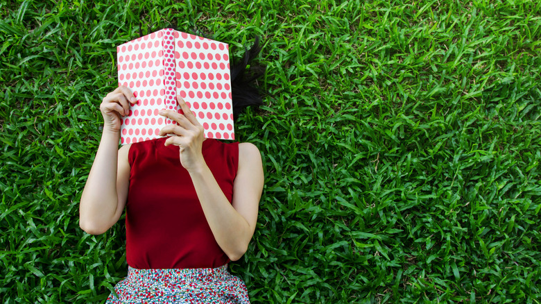 Reading a book laying on the grass