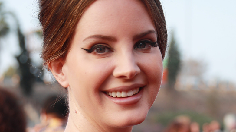 Lana Del Rey smiling with an updo