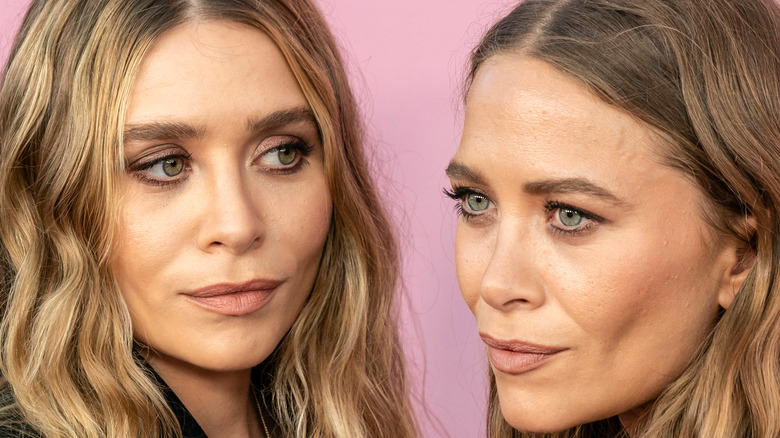 Mary Kate and Ashley Olsen posing at event together
