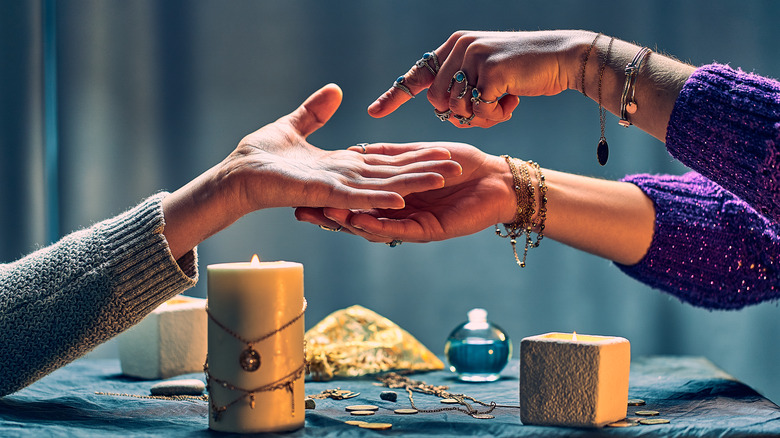 A palm reader examines hand