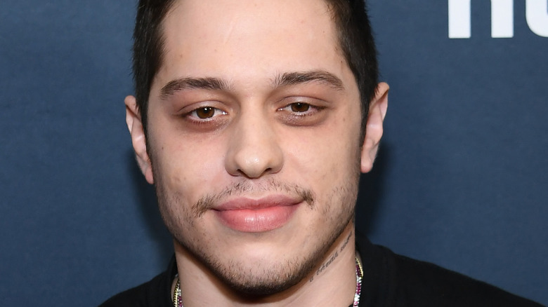 Pete Davidson grinning with facial scruff