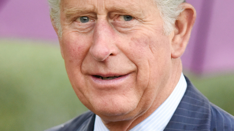 Prince Charles holding an umbrella