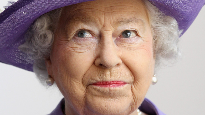 Queen Elizabeth II smiling in purple