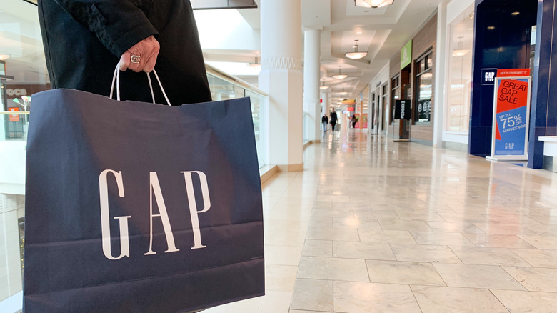 Shopper holds a Gap shopping bag in the mall