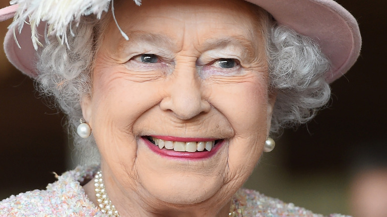 Queen Elizabeth II smiling in pink