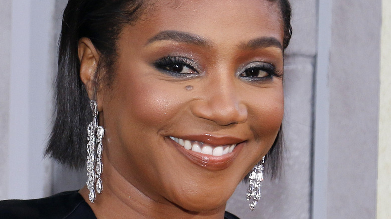 Tiffany Haddish smiling with shiny earrings