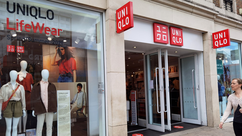 Two red Unilqlo signs hung up on a tile wall 