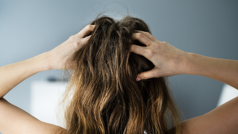 Woman touching her scalp