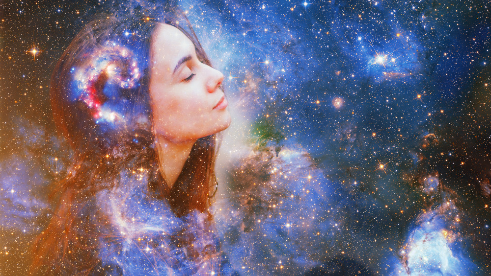 A woman in front of a background full of stars and cosmic images