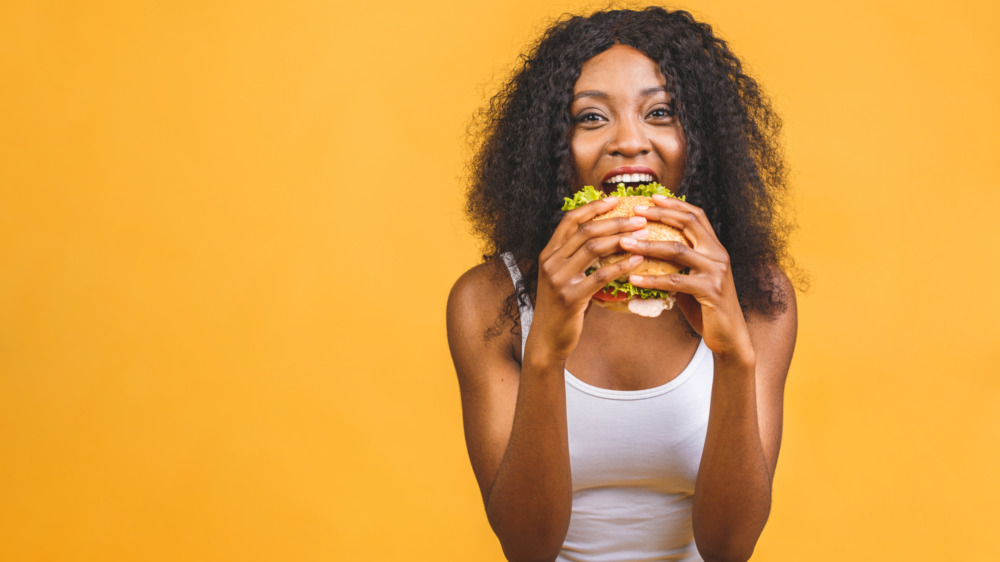 Woman happily eating burger