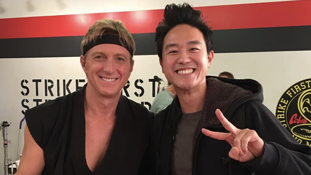 Cobra Kai's William Zabka, Joe Seo smiling in dojo