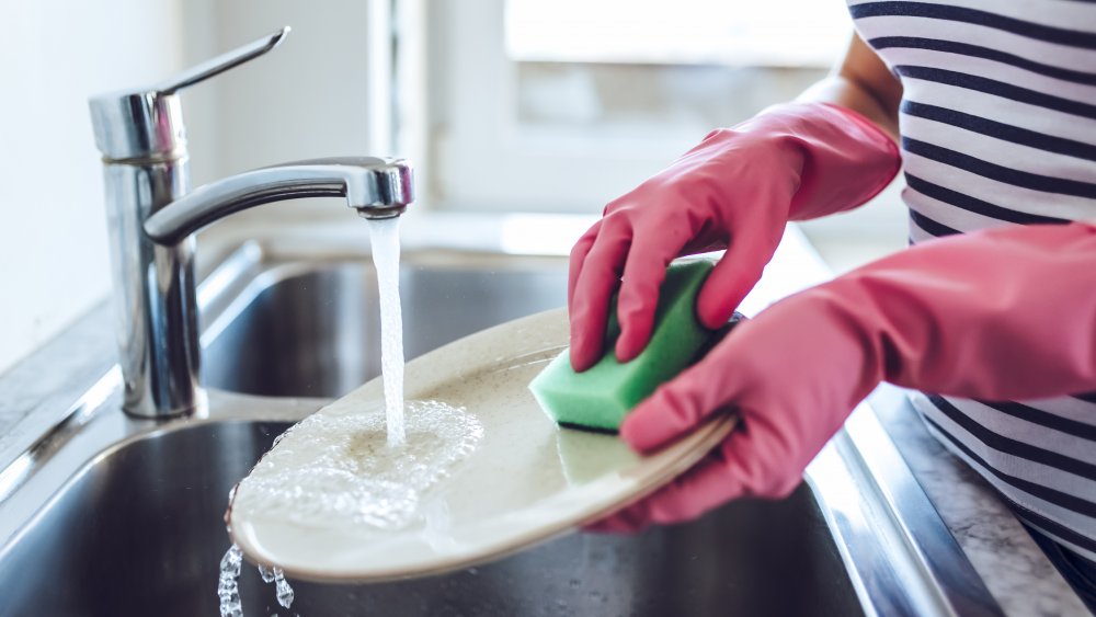 woman handwashing plates