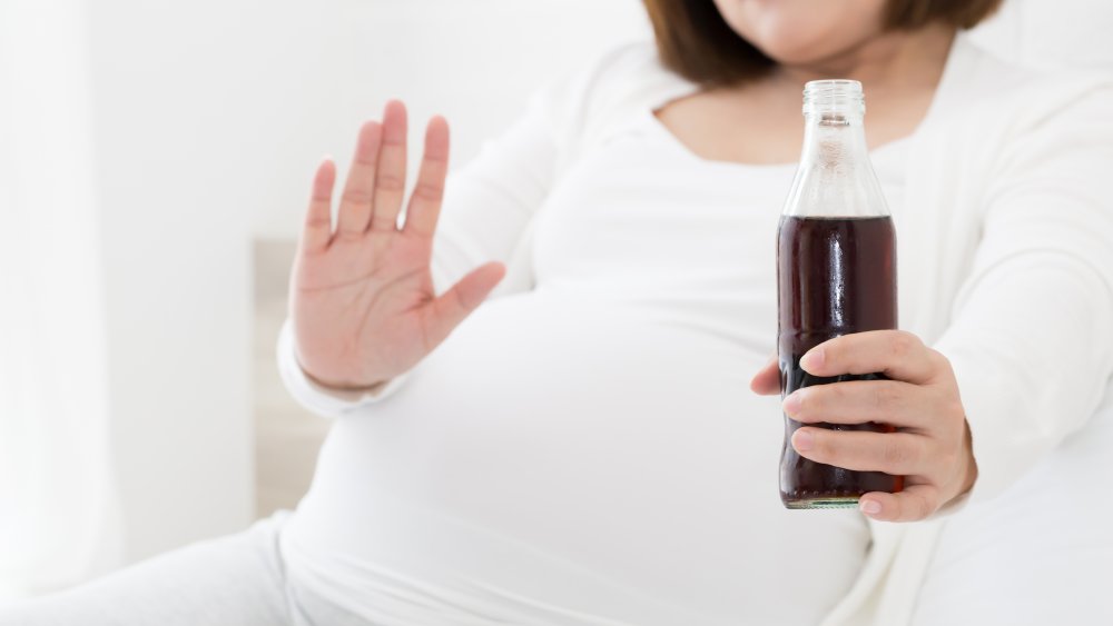 Pregnant woman drinking soda