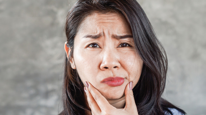 Woman cupping her jaw