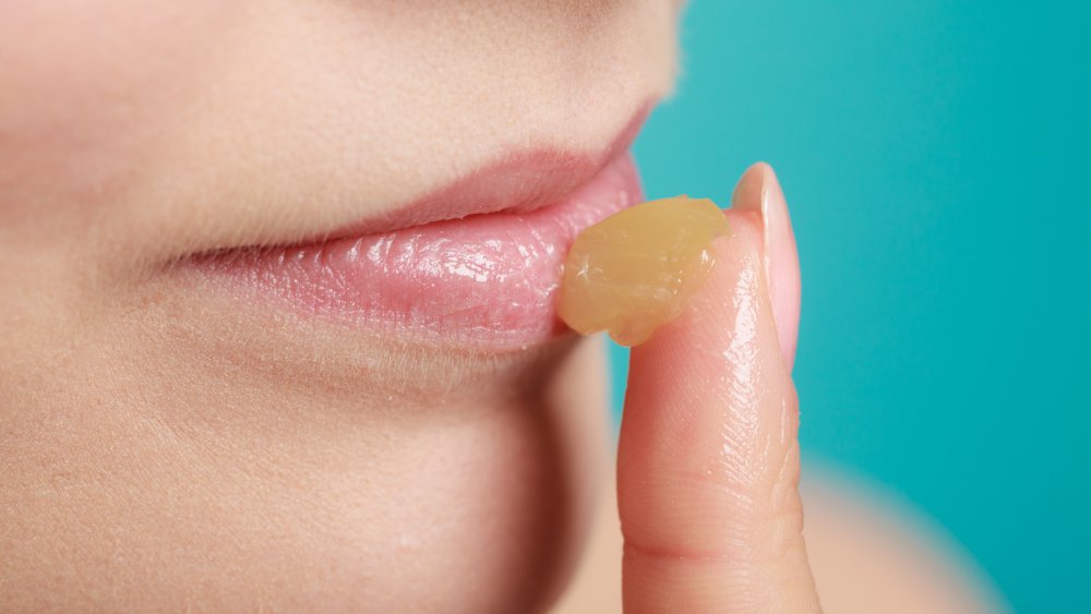 Woman applying lip balm to chapped lips