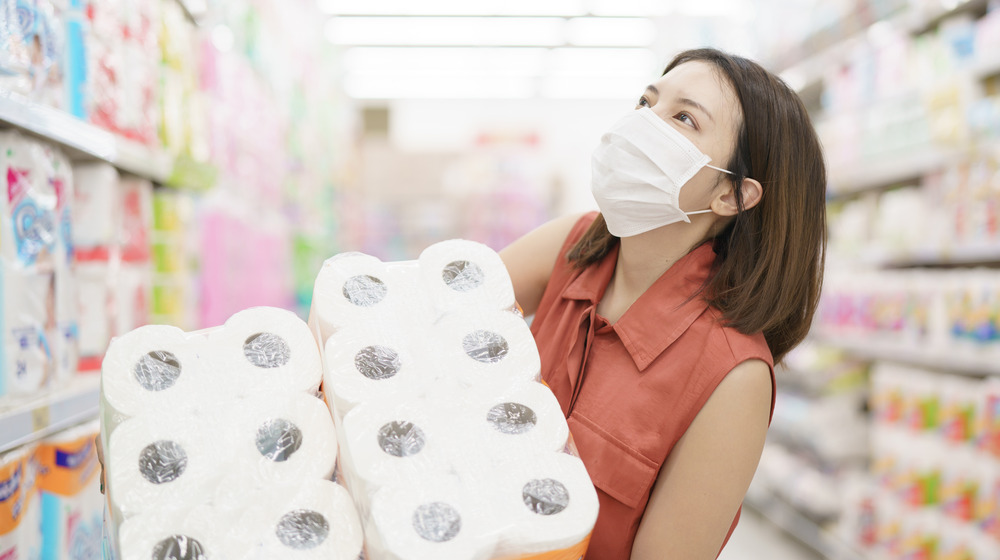 woman carrying toilet paper