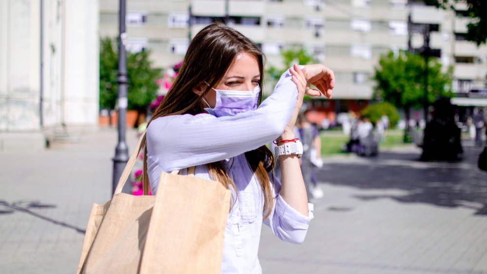 Woman coughing into her elbow