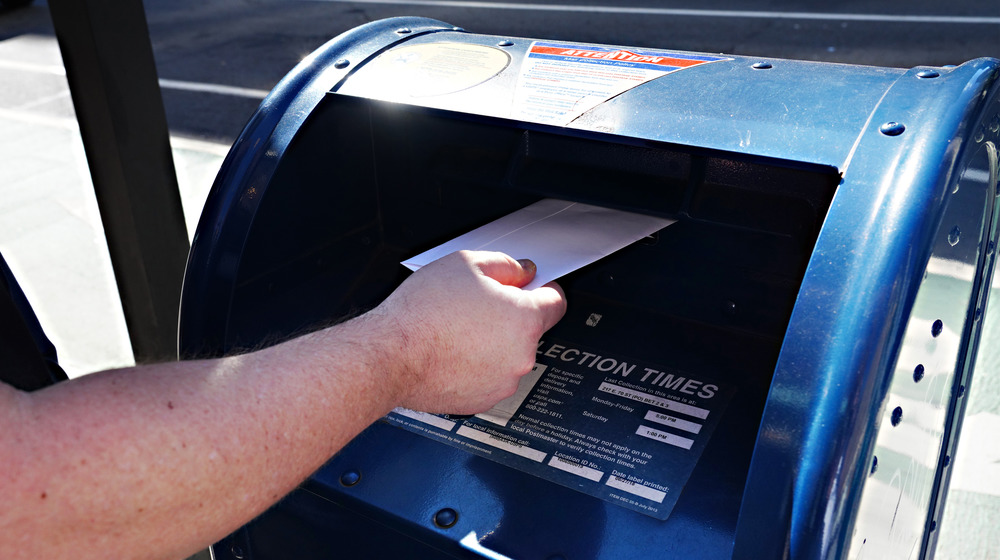 Letter being inserted into mailbox