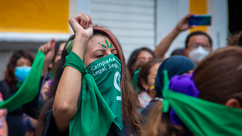 women wearing green scarves at an abortion rally