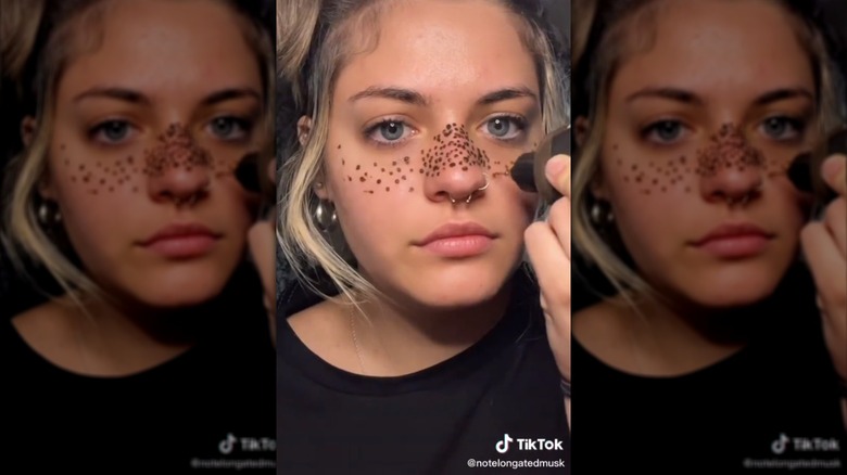 TikTok screenshot of white creator applying henna freckles