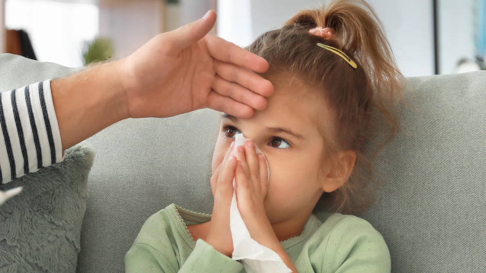 Father taking care of his daughter at home with the flu 