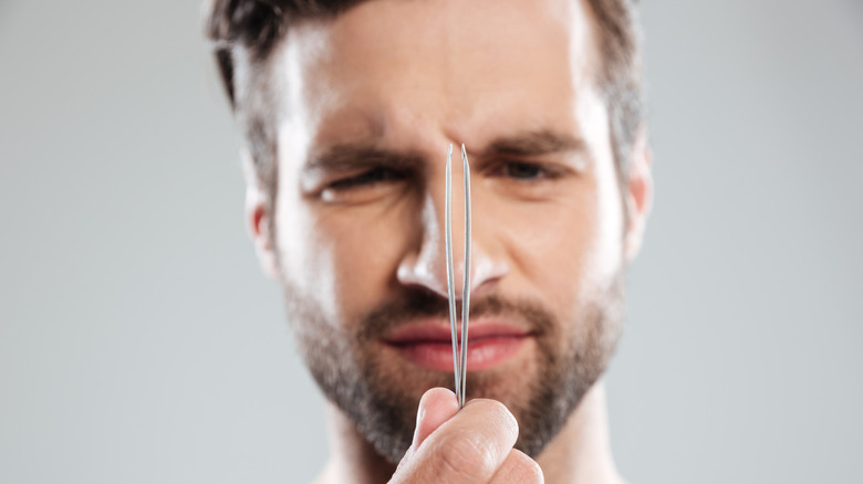 Man holding tweezers