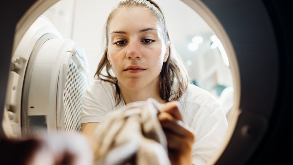 Woman putting clothes in the dryer