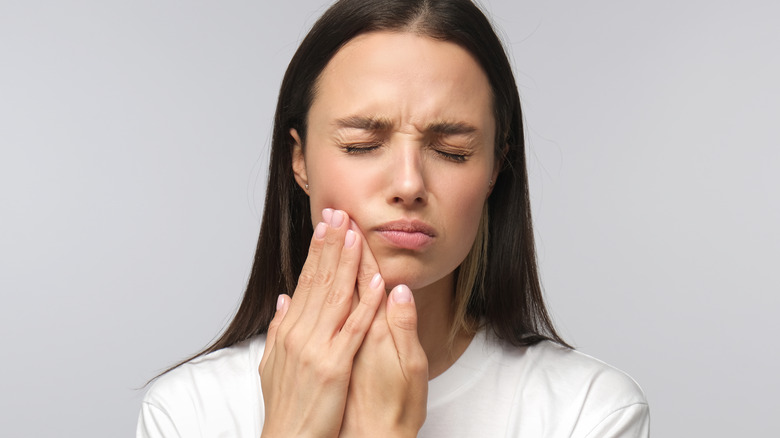 Young brunette woman experiencing jaw pain 