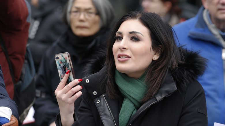 Laura Loomer posing with phone in hand