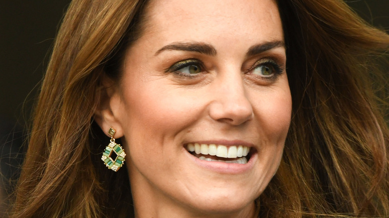 Kate Middleton smiling with hair down and emerald earrings
