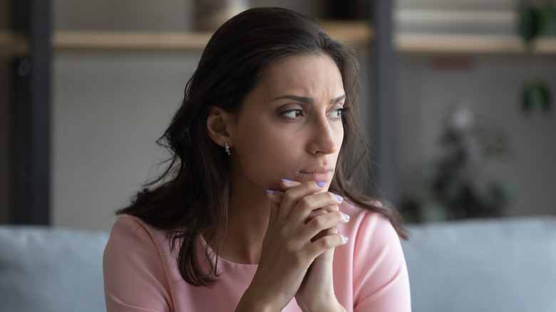 Woman leaning head in hands and looking sad