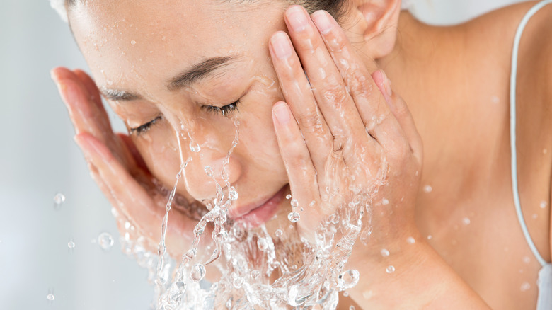 Woman splashing face with water