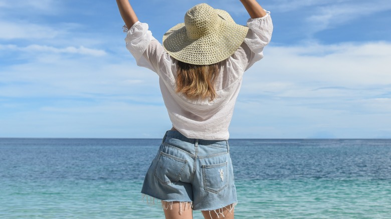 Woman by the sea in denim shorts