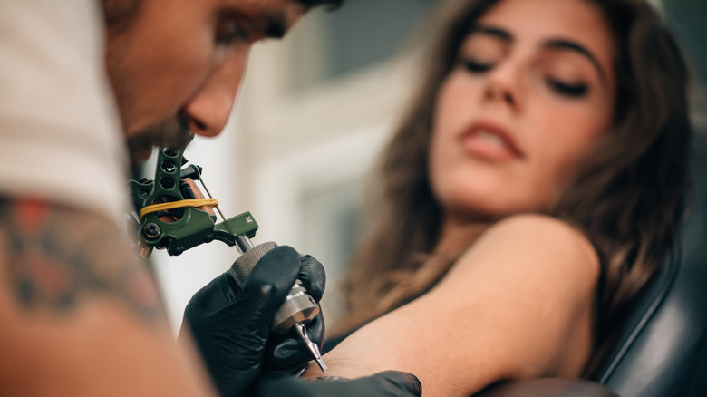 woman getting new tattoo in studio