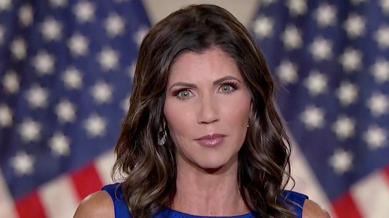Kristi Noem in a blue outfit, staring straight ahead