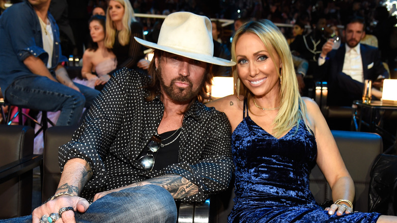 Tish and Billy Ray Cyrus posing for pics at an event
