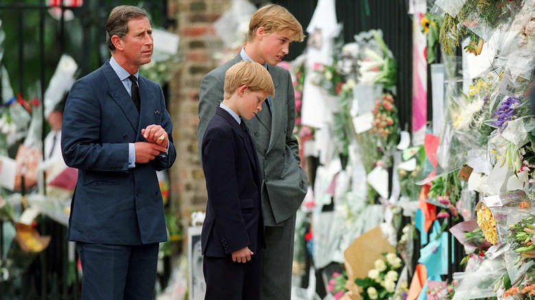 King Charles, Prince William, and Prince Harry observing the flowers left for Princess Diana in 1997